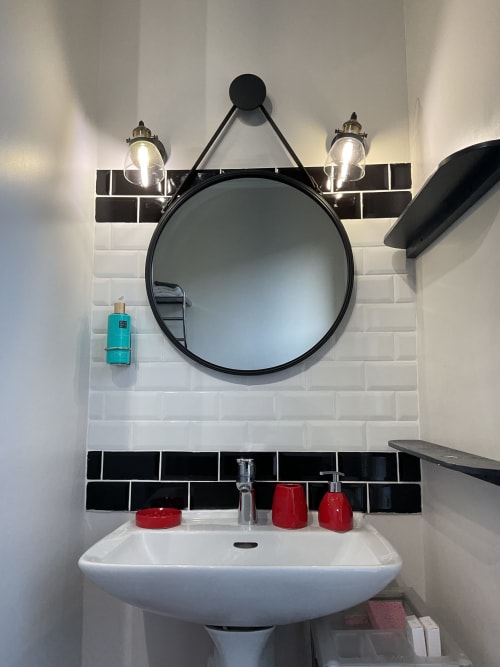 Salle de bain moderne avec miroir rond et éclairage élégant, maison d’hôtes à Evry, Essonne, France, propreté, confort, bien-être, accueil