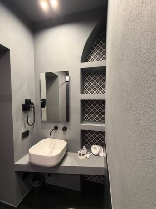 Bagno moderno nella Volta 70 Deluxe Room, Napoli con lavabo bianco, ripiani in piastrelle bianche e nere, specchio e