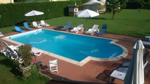 Il Casale di Nanni swimming pool with loungers and umbrellas in Lucca, Italy