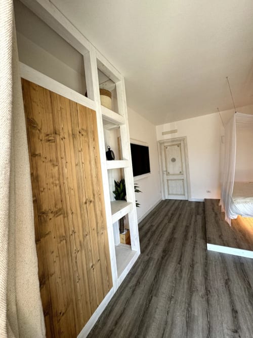 Camera moderna di Villa Carrie Porto Pozzo con guardaroba in legno, scaffali e pavimento in legno scuro