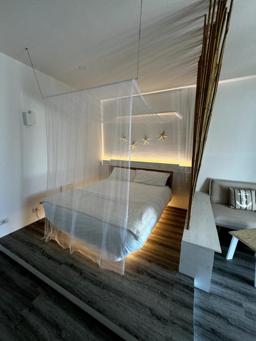Camera da letto moderna con baldacchino trasparente a Villa Carrie Porto Pozzo, Santa Teresa Gallura, pavimenti in legno e illuminazione ambient