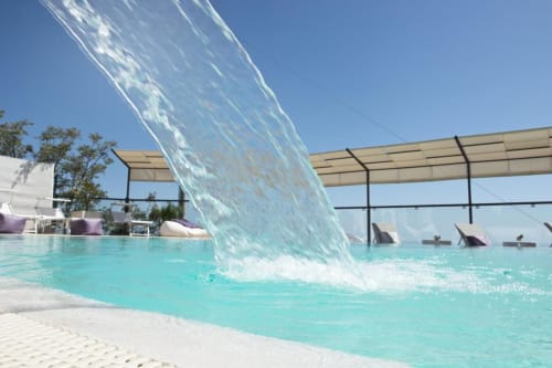 Wasserfall stürzt in türkisblaues Becken des Al Mirador Resort in Fasano, Italien