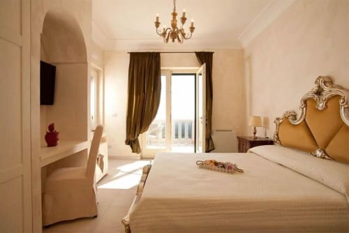 Luxussuite im Al Mirador Resort in Fasano mit goldener Kopfleiste, Meerblick-Balkon und eleganter klassischer Einrichtung