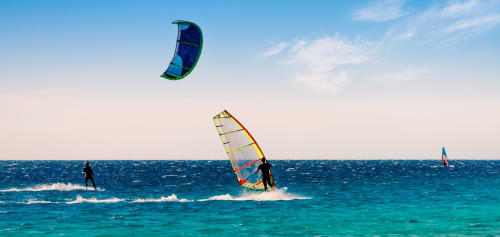 Windsurfers and kitesurfers enjoying turquoise waters near Residenza la Pietra in Pietra Ligure, Italy