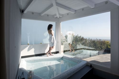 Woman in white robe at Al Mirador Resort's luxury bathroom with hot tub overlooking Fasano coastline and sea views
