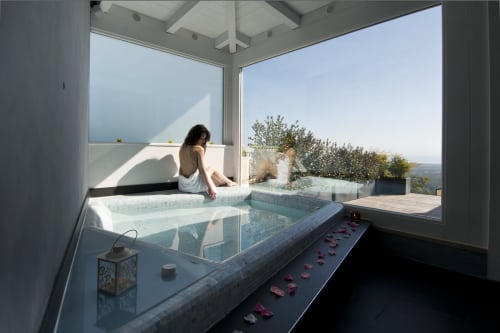 Woman relaxing in bathtub at Al Mirador Resort, Fasano, with scenic landscape views and petals