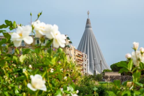 Fiori bianchi incorniciano una moderna cappella dal tetto conico a Siracusa, vicino al bed and breakfast Corte Sicula