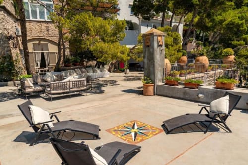 Terrazza panoramica soleggiata di La Conciergerie Capri con lettini, bussola decorativa, piante in vaso e vista mare