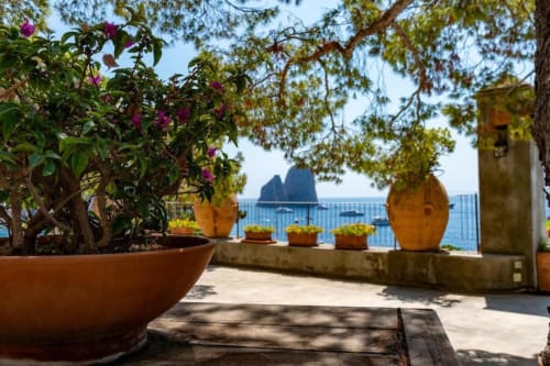 Terrazza fiorita di Villa La Conciergerie Capri con piante in vaso e vista sui Faraglioni