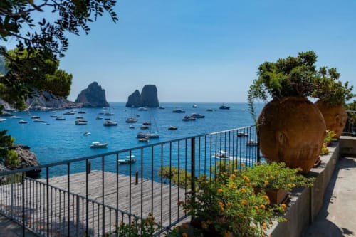 Villa a Capri con vista mare spettacolare su barche e caratteristiche formazioni rocciose nelle cristalline acque blu del Mediterraneo