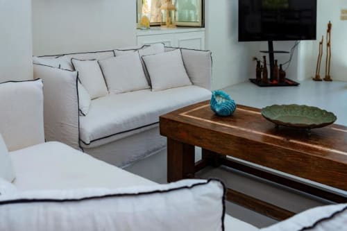 Elegante soggiorno di villa moderna a La Conciergerie Capri con divano grigio chiaro, tavolino in legno e vista mare