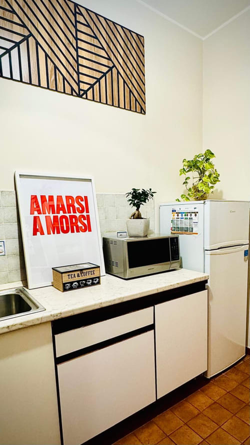 Cucina moderna nell'Apartment Todo Sicilia a Catania con elettrodomestici bianchi, microonde, angolo caffè e piante in vaso