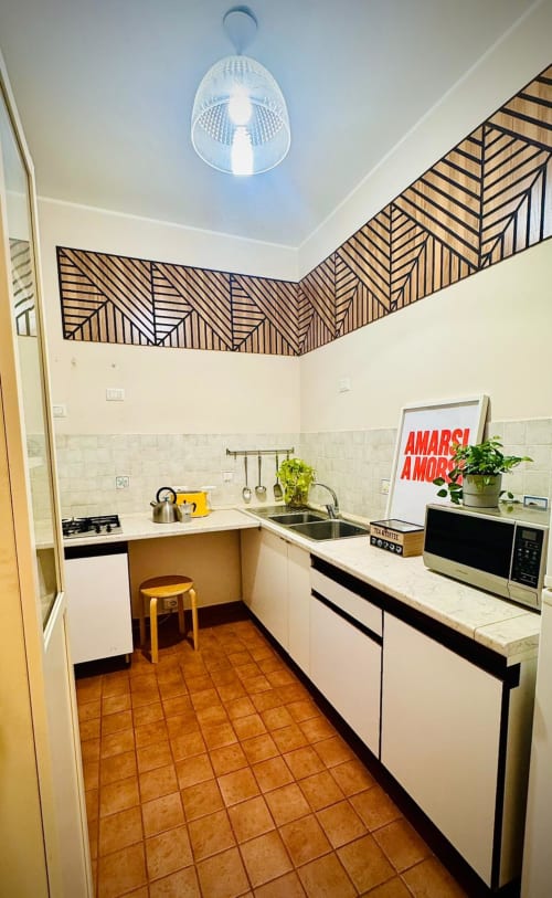 Cucina moderna nell'Appartamento Todo di Catania, Sicilia, con arte geometrica a parete, elettrodomestici in acciaio inox e piastrelle in terracotta