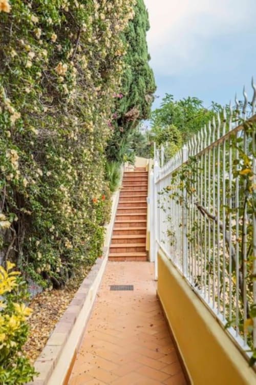 Suggestivo sentiero coperto di edera con scalinata in terracotta alla villa La Conciergerie di Capri