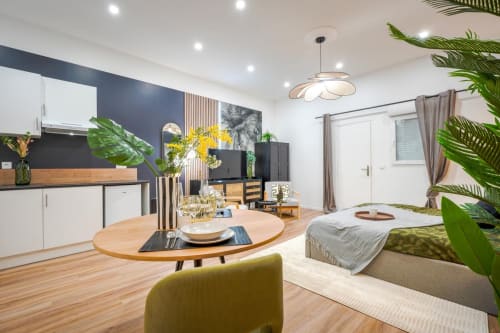 Modern Urban Chic apartment at Wellkhome Bordeaux with open-plan living, dining area, kitchen, bed, plants, and contemporary