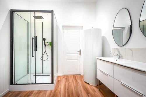 Modern bathroom with walk-in shower, vanity, round mirror at Wellkhome Bordeaux Urban Chic apartment
