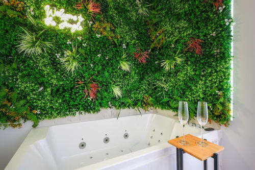 Luxury jacuzzi bathtub with green living wall at Wellkhome Bordeaux Urban Chic apartment, champagne glasses on wooden tray