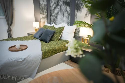 Modern Urban Chic bedroom at Wellkhome Bordeaux with green patterned bedding, city view, and potted plants