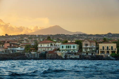 Vista del waterfront di Catania con edifici colorati e l'Etna al tramonto, Sicilia