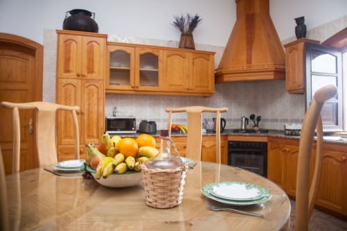 Wooden kitchen with dining table, fresh fruit bowl, and place settings at Finca de La Geria cottage in Yaiza