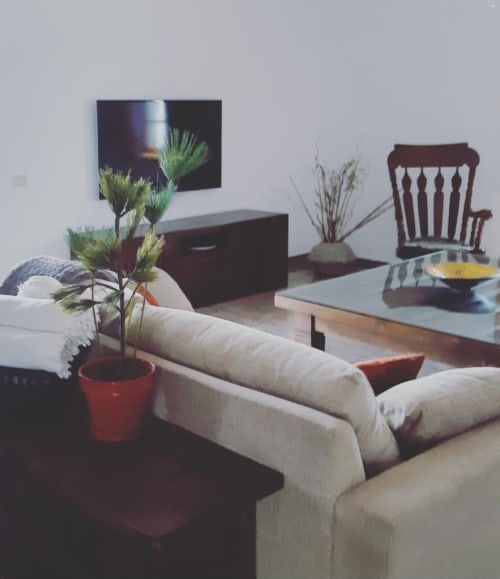 Spacious living room at Finca de La Geria cottage with cream sofa, potted plant, wooden chair, and garden views in Yaiza