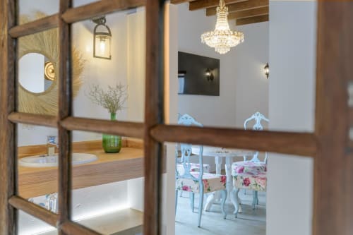 Elegant cottage entrance at Finca de La Geria with wooden framed glass doors, chandelier, and refined interior décor