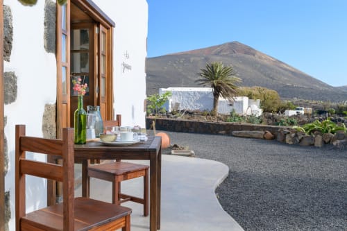 Outdoor dining area at Finca de La Geria cottage in Lanzarote with mountain views and volcanic landscape