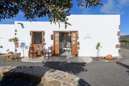 El Granero cottage at Finca de La Geria in Yaiza with wooden doors, terrace seating, and mountain views