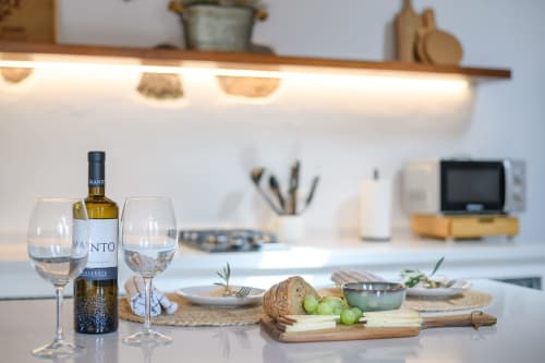 Modern kitchen dining area at Finca de La Geria cottage with wine, cheese board, and garden views