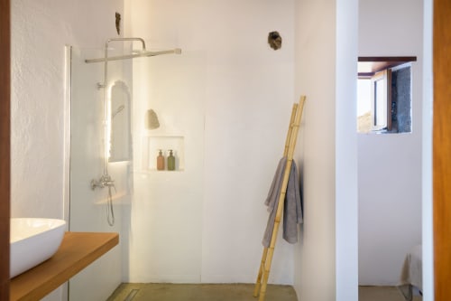 Modern bathroom at Finca de La Geria cottage with walk-in shower, wooden vanity, white vessel sink, and mountain views from