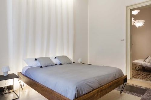 Camera moderna in Todo Sicily Apartment a Catania con letto in legno, biancheria blu, tende bianche e bagno ensuite