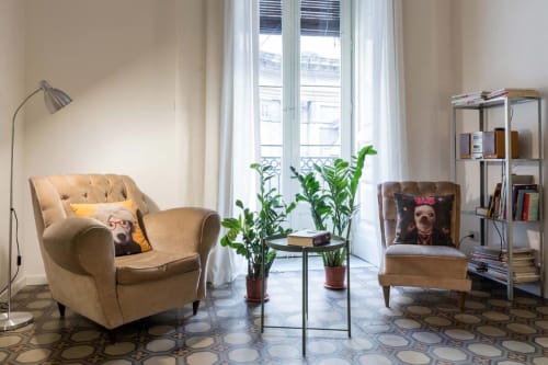 Luminosa sala del Bright Catania B&B con poltroncine beige, piante verdi, lampada da terra e vista sulla città dalle grandi finestre