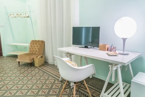 Spazio di lavoro moderno nella Todo Sicily B&B con scrivania bianca, TV a schermo piatto e pareti verde salvia a Catania