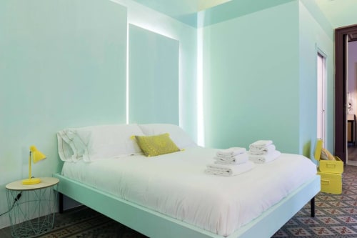 Camera luminosa e moderna del Todo Sicily B&B a Catania con pareti verde menta, letto bianco e dettagli gialli