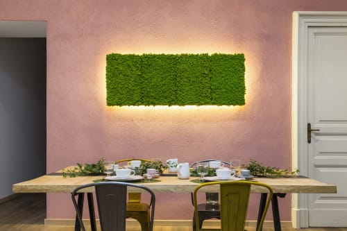 Zona pranzo moderna presso Todo Sicily B&B con tavolo in legno, parete decorativa in muschio verde e pareti rosa con texture a Catania