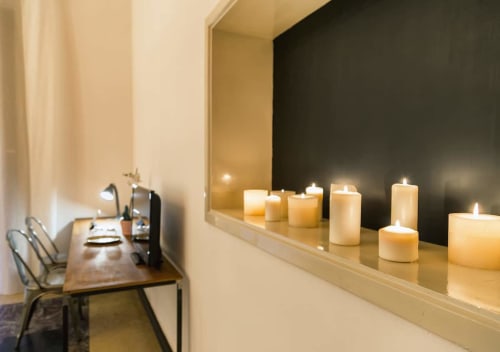 Elegante spazio di lavoro nella Fire room di Todo Sicily B&B con candele accese su ripiano e scrivania con lampada da lettura