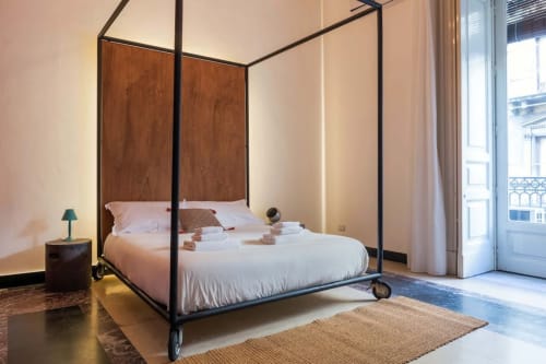 Letto a quattro colonne con struttura in legno nella camera Fire del Todo Sicily B&B, Catania, con vista sul balcone