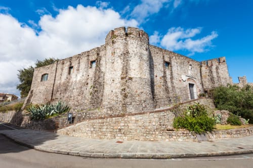 Storica torre castello in pietra a Bologna, Italia con architettura medievale e cielo azzurro limpido