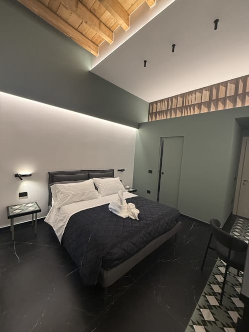 Camera Deluxe Doppia Moderna a Volta 70 a Napoli con pavimenti in marmo nero, pareti verdi, luci ambientali al soffitto e