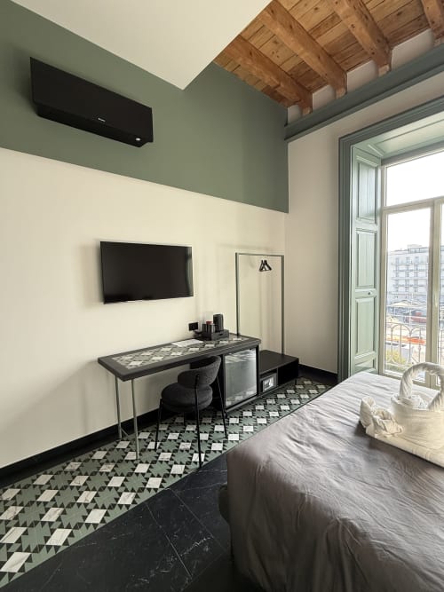 Camera deluxe con balcone vista città, scrivania con TV, comfort moderni e travi in legno a vista a Volta 70 Napoli