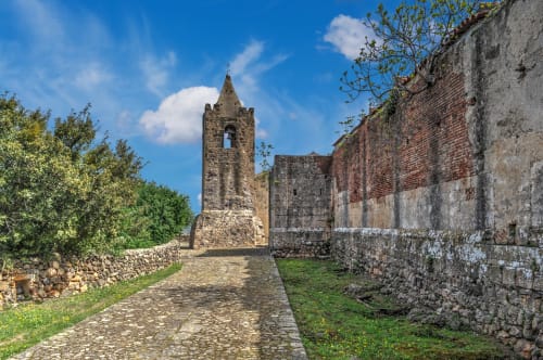 Ancient stone tower and ruins along a pathway in Orosei, Italy, near Loddo Paola accommodation