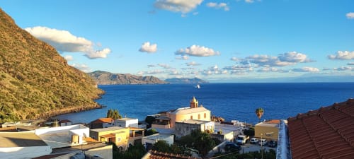 L'Hotel Principe di Rinella si affaccia sul blu del Mar Mediterraneo di Rinella con edifici colorati e scogliere vulcaniche