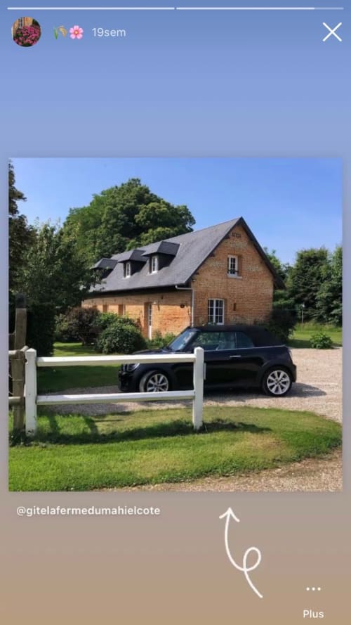 Gite Le Clos Mahiel : bâtisse en brique, toiture en ardoise, clôture blanche et parking pour les voitures dans le grand jardin.
