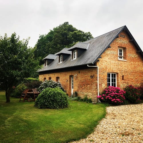 Gîte Brise de Lin, charmante maison en briques avec jardin, hortensias roses, pelouse bien entretenue et terrasse en graviers