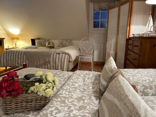 Chambre charmante du Clos Mahiel avec lits, fleurs et lumière chaleureuse à Saint-Romain-de-Colbosc