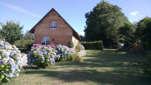 Maison en briques avec hortensia bleu dans le jardin du Clos Mahiel, Saint-Romain-de-Colbosc, France