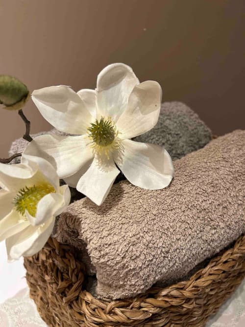 Fleurs d'anémone blanche composent le panier des serviettes taupes du gite au Clos Mahiel. Serviettes de bain comprises.