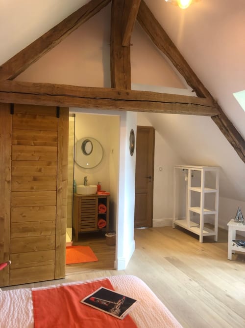 Chambre Skipper-Vent d'Ouest au Clos Mahiel : chambre mansardée aux poutres apparentes, salle de bain privée, rangements blancs et luminosité