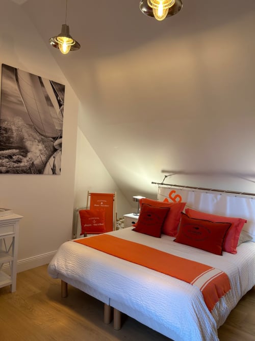 Chambre contemporaine du Clos Mahiel avec accents orange, luminaires suspendus et décoration nautique à Saint-Romain-de-Colbosc