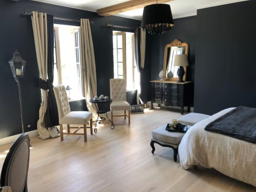 Chambre d'hôtes très raffinée et élégante au Clos Mahiel avec décoration bois et murs foncés, coin salon et vue sur le jardin